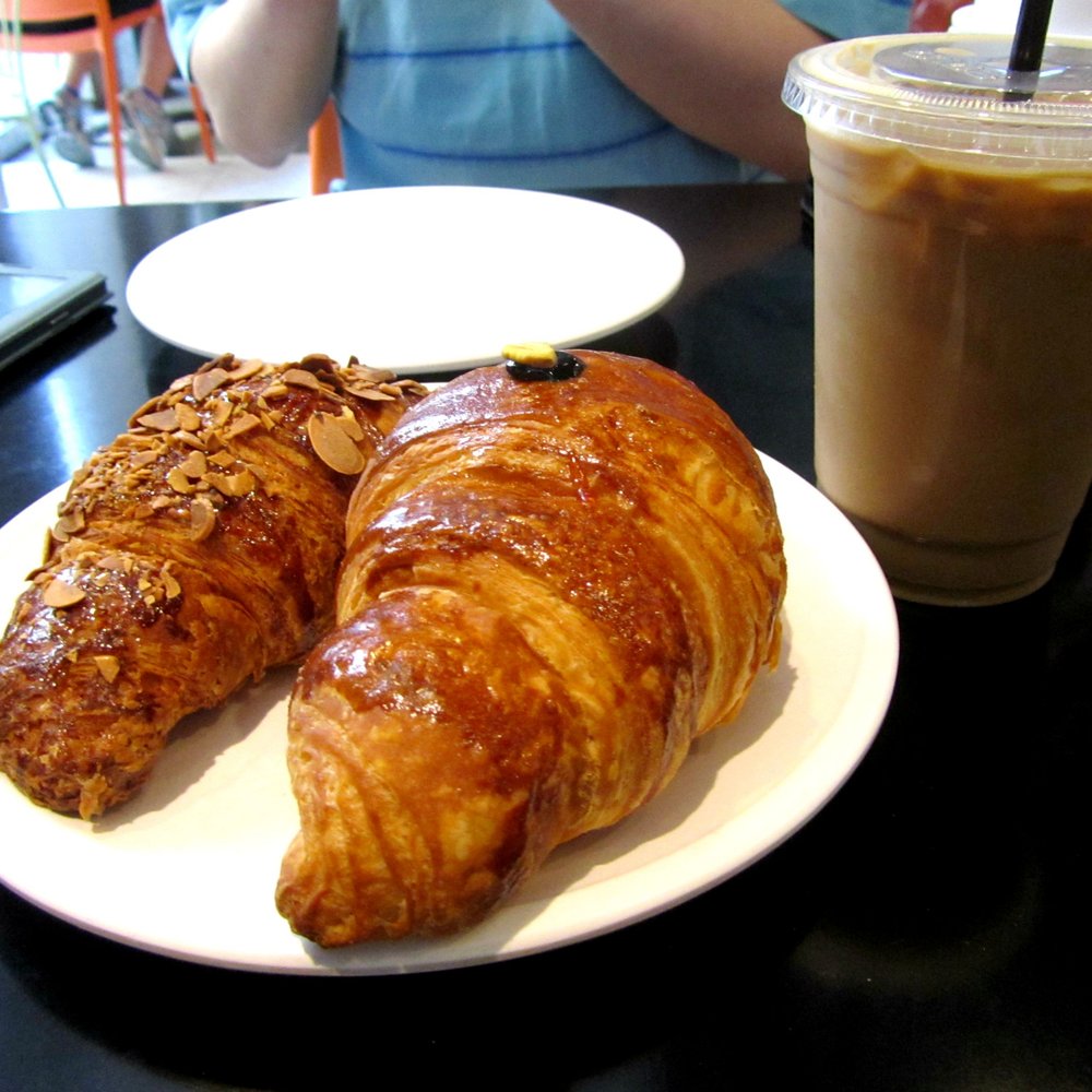 Hendrickx Belgian Bread Crafter - (L to R) Almond Croissant, Pistachio Croissant, and a Belgian-style Iced Coffee. - Bakeries Near Me - Chicago, Illinois