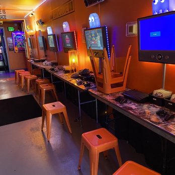 Domestique Satellite - a row of orange stools and a flat screen tv - Coffee & Tea Near Me - Birmingham, Alabama