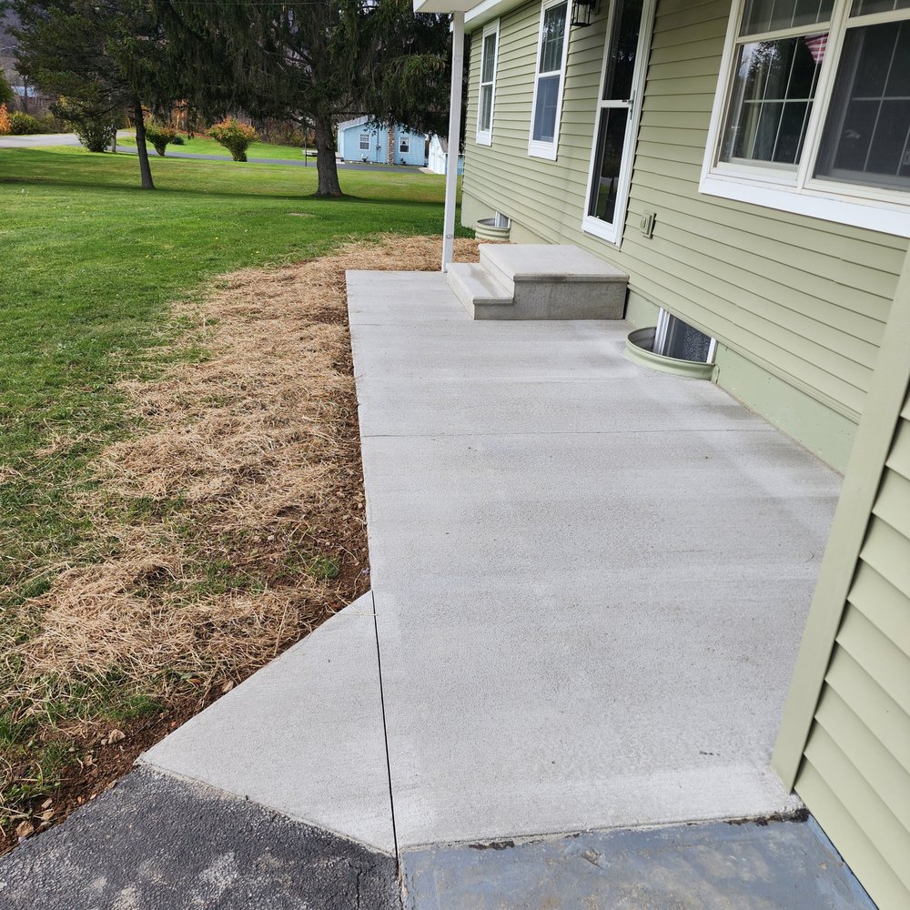 Knowles PaulPAK Construction - a view of the front of a house with a concrete walkway and a concrete step - General Contractors Near Me - Guilford, New York Knowles PaulPAK Construction - a view of the front of a house with a concrete walkway and a concrete step - General Contractors Near Me - Guilford, New York