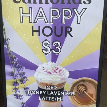 Edmonds Cafe - Happy Hour - A printed promotional sign from Edmonds Cafe features a purple, yellow, and white background with a lavender flower and a honey dipper. It advertises a happy hour offering a lavender honey latte for $3 every Wednesday from 3 to 5 pm. The sign includes an image of a lavender honey latte topped with whipped cream and a swirl of syrup, along with a honey dipper in a wooden bowl. - Cafes Near Me - Berkeley, California