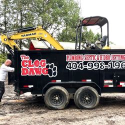 The Clog Dawg Plumbing & Hydrojetting - Technicians loading excavator into work trailer