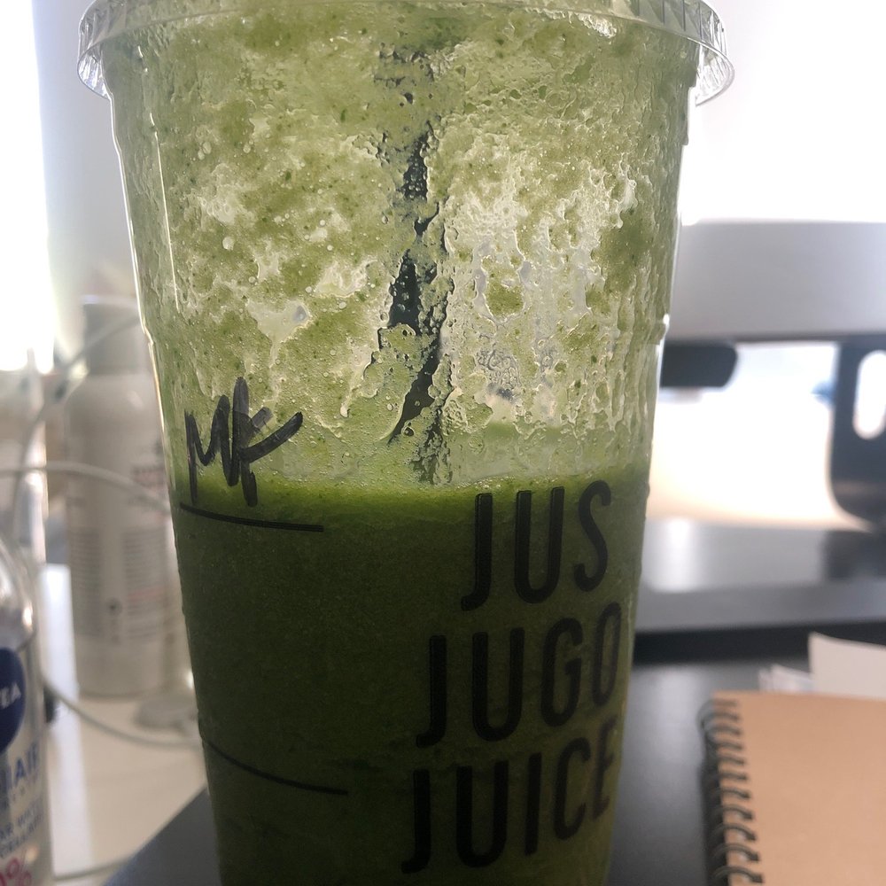 a green smoothie in a plastic cup