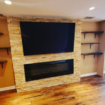 Dettmer Designs - a flat screen tv mounted on a stone fireplace - General Contractors Near Me
