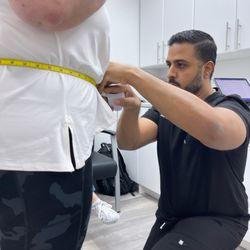 Total Weight and Wellness Solutions - Dr. Faisal Huda MD doing waist measurements
