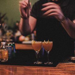 Clara - Two Smooth Sailing cocktails. Featuring Whiskey, Lemon Juice, Maple Syrup, and Benedictine.