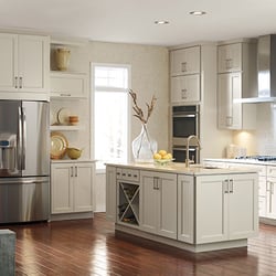 Gerhard's Kitchen Bath & Lighting Store - Kemper cabinetry in cream color with large island featuring stainless steel appliances and tile backsplash.