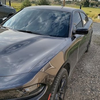 Tinted - A dark grey Dodge Charger parked on a gravel surface, showcasing tinted side windows that contrast with the reflective windsh... - Windshield Installation & Repair Near Me - Billings, Montana Tinted - A dark grey Dodge Charger parked on a gravel surface, showcasing tinted side windows that contrast with the reflective windsh... - Windshield Installation & Repair Near Me - Billings, Montana