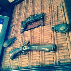 Cottage Bar - Antique pistols displayed at bar.
