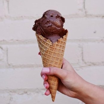 Scoops Clarkesville - a hand holding a cone of chocolate ice cream - Ice Cream & Frozen Yogurt Near Me - Clarkesville, Georgia Scoops Clarkesville - a hand holding a cone of chocolate ice cream - Ice Cream & Frozen Yogurt Near Me - Clarkesville, Georgia