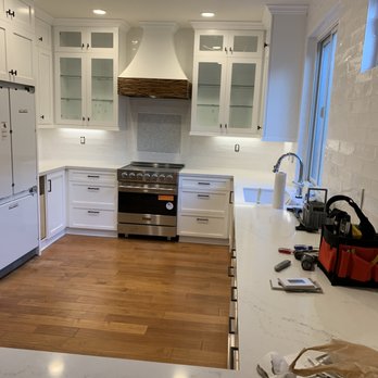Pat Edwards Construction - a kitchen with white cabinets and wood floors - General Contractors Near Me Pat Edwards Construction - a kitchen with white cabinets and wood floors - General Contractors Near Me
