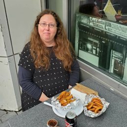 Me eating chicken fingers and onion rings at Mendy's Deli outdoor dining. Me eating chicken fingers and onion rings at Mendy's Deli outdoor dining.