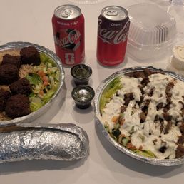 Two rice bowls, one falafel and one lamb. Sauces, drinks, pita. Two rice bowls, one falafel and one lamb. Sauces, drinks, pita.