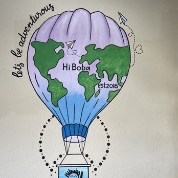 Hi Boba - A wall mural depicts a hot air balloon with a world map design, the Hi Boba logo, and the phrase 'let's be adventurous,' with decorative paper airplanes. - Coffee & Tea Near Me - Rio Rancho, New Mexico