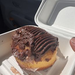 A donut with smashed icing and a bit of brown icing from another donut. A donut with smashed icing and a bit of brown icing from another donut.