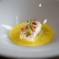 Essential by Christophe - Poached bass in a golden saffron curry -- French technique meets global flavor at Essential by Christophe