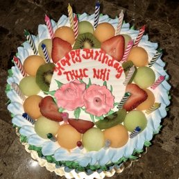 a birthday cake decorated with fruit and candles