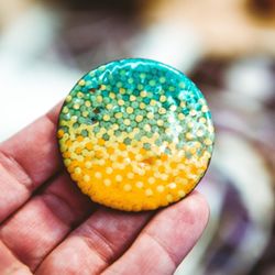Boulder Metalsmithing Association - Student holds their pin they created in our enameling workshop.