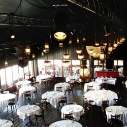 Le Café du Port - Grande salle dans un hangar avec des tables rondes nappées