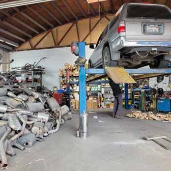 Yao Auto Repair - Car on hoist is on the right, and old mufflers and such on the left. - Auto Repair Near Me - Oakland, California