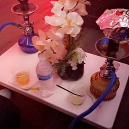 a table with a hookah and a vase of flowers