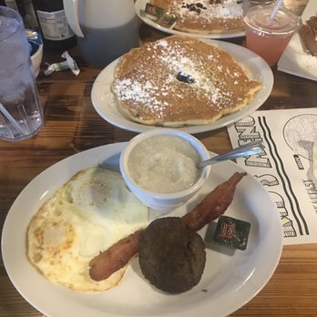 Old West Cafe - My lemon blueberry pancake along with grits, eggs, bacon & sausage. - Breakfast & Brunch Near Me - Grapevine, Texas Old West Cafe - My lemon blueberry pancake along with grits, eggs, bacon & sausage. - Breakfast & Brunch Near Me - Grapevine, Texas