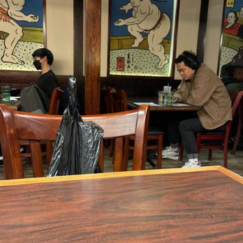 Ajisen Ramen - two men sitting at a table in a restaurant - Ramen Near Me - New York, New York