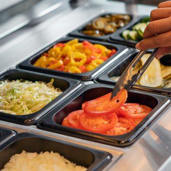 Harvey's - a person preparing food in a buffet - Burgers Near Me - Saint-Eustache, Quebec Harvey's - a person preparing food in a buffet - Burgers Near Me - Saint-Eustache, Quebec
