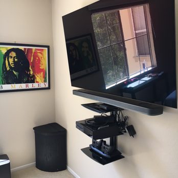 K&S Systems - My bedroom 65 inch flat; with a flush slim LG tv mount, as well as wall mount shelves underneath, and a fresh paint job to blend it all in. - Home Theatre Installation Near Me - Orange, California