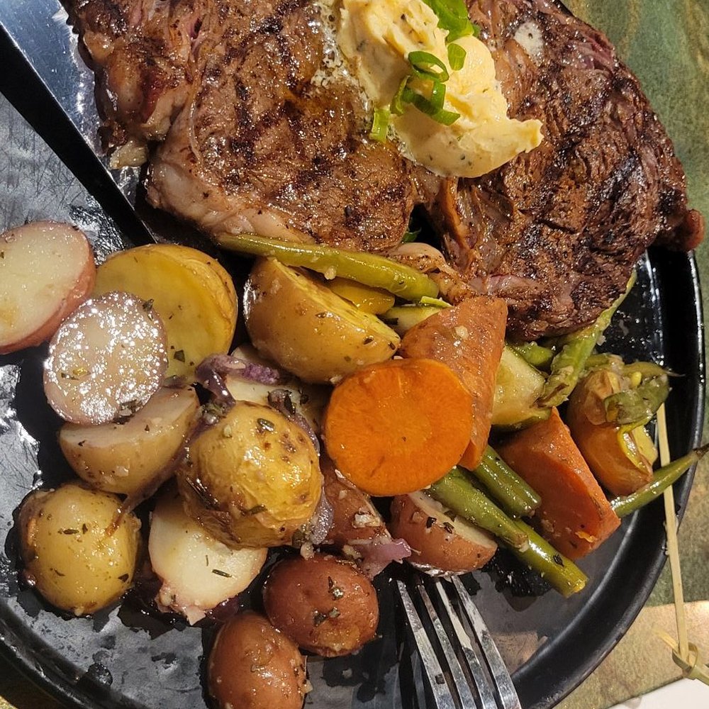 Ribeye Steak w/potatoes & mixed vegetables. Glass of water w/lemon wedges. Ribeye Steak w/potatoes & mixed vegetables. Glass of water w/lemon wedges.