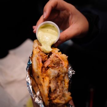 Arepas TO GO - a person holding a sandwich - Colombian Near Me - Woodside, New York Arepas TO GO - a person holding a sandwich - Colombian Near Me - Woodside, New York