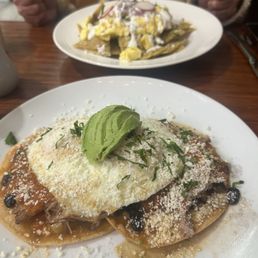 Rancheros con carnitas in the front, chilaquiles verdes in the back. Rancheros con carnitas in the front, chilaquiles verdes in the back.