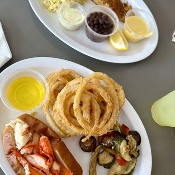 Steamers of Naples - Scamp grouper with black beans and rice and a Hot lobster roll with onion rings and veggies. - Seafood Near Me - Naples, Florida Steamers of Naples - Scamp grouper with black beans and rice and a Hot lobster roll with onion rings and veggies. - Seafood Near Me - Naples, Florida