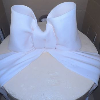 CEG Bakery - 10 inch vanilla cake with cream cheese, icing between layers, light pink buttercream icing, and a fondant bow :) - Bakeries Near Me - Atlanta, Georgia