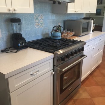 Huezo Tile & Marble - a kitchen with white cabinets and stainless steel appliances - Flooring Near Me Huezo Tile & Marble - a kitchen with white cabinets and stainless steel appliances - Flooring Near Me