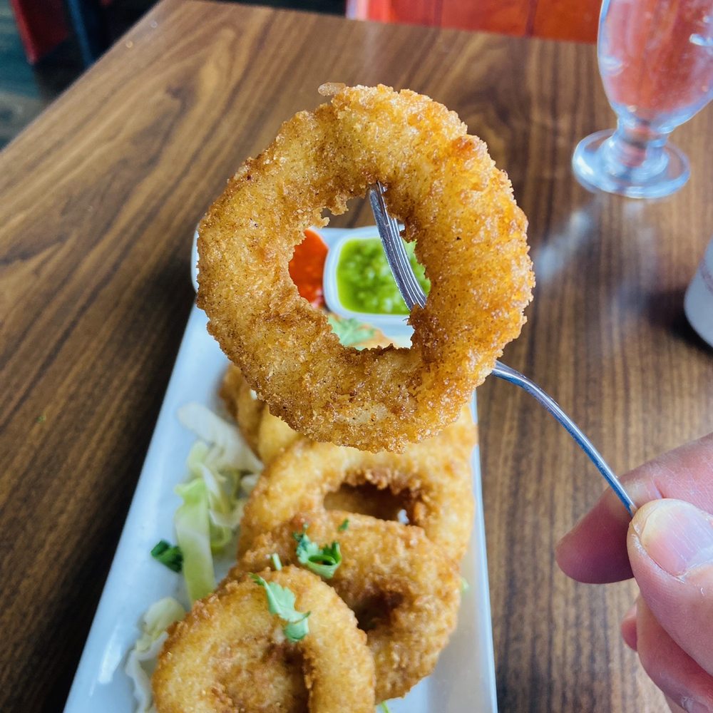 Kalai's Dosa Hut - a hand holding a fork and a plate of onion rings - Indian Near Me - Vancouver, British Columbia Kalai's Dosa Hut - a hand holding a fork and a plate of onion rings - Indian Near Me - Vancouver, British Columbia