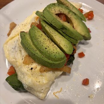 Denny's - Build Your Own Omelette - A breakfast omelette topped with sliced avocado and small diced tomatoes, served on a white plate. - Breakfast & Brunch Near Me - Payson, Arizona