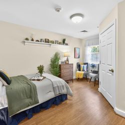 Artis Senior Living of Potomac - Memory care suite with bed, personal photo shelving, and accessible design for comfort and easy navigation.