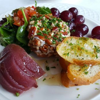 Emilio's Tapas - Queso De Cabra Con Nueces $8.95 goat cheese rolled in caramelized pecans, served with poached pear in red wine, grapes and toast points - Spanish Near Me - Hillside, Illinois