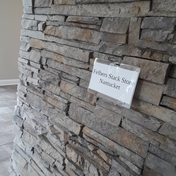 LJ Construction - a sign on a stone wall - Roofing Near Me - Lancaster, New York