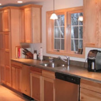 Valley Kitchens - a kitchen with wood cabinets and stainless steel appliances - General Contractors Near Me - Southampton, Massachusetts