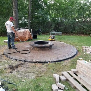 DMT Contractors - a man working on a fire pit - Landscaping Near Me