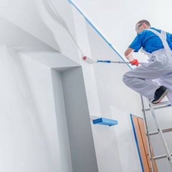 EE Renovations - a man on a ladder painting a wall - General Contractors Near Me - Ottawa, Ontario