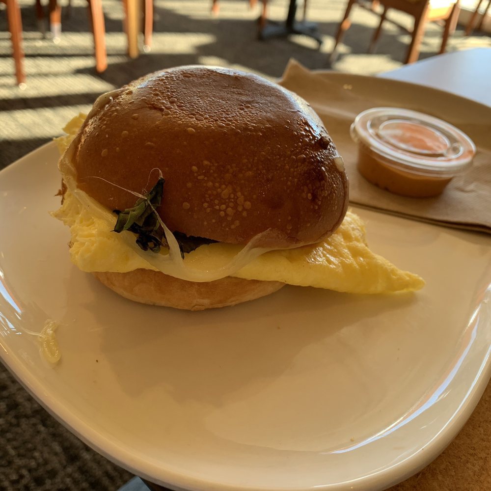Scrambled eggs with tomatoes & basil on brioche bun. Scrambled eggs with tomatoes & basil on brioche bun.