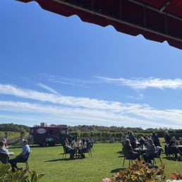 a group of people sitting at tables outside