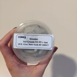 a person holding a container of ice cream