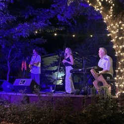 Walt and Tina Wilkins and Roy Flint singing and playing on the deck.