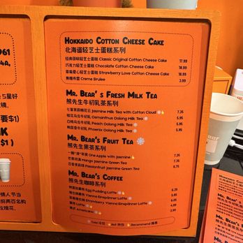 Mr Bear - Menu board at Mr. Bear features cotton cheesecakes, milk teas, fruit teas, and coffee options with prices, in a bright orange design. - Desserts Near Me - Queens, New York