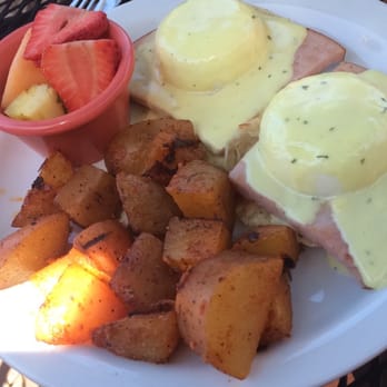 Wildflower Cafe - 2 eggs benedict on turkey, and a muffin covered in hollandaise sauce; with a side of potatoes and fruit - Breakfast & Brunch Near Me - Redondo Beach, California