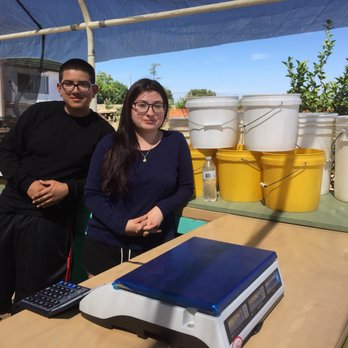Gil Ranch U-pick - a man and a woman standing in front of a solar panel - Pick Your Own Farms Near Me - Brentwood, California