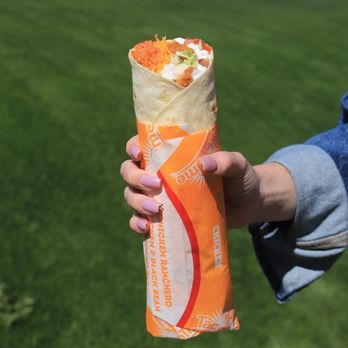 Taco Time - a person holding a burrito in their hand - Mexican Near Me - Brigham City, Utah Taco Time - a person holding a burrito in their hand - Mexican Near Me - Brigham City, Utah